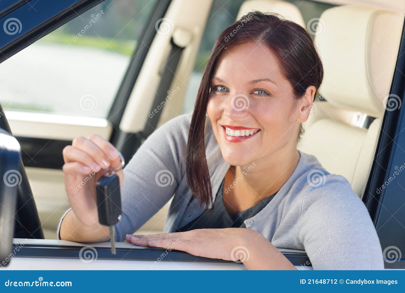 Attractive businesswoman in new car showing keys. Attractive elegant businesswoman in new car showing keys smiling