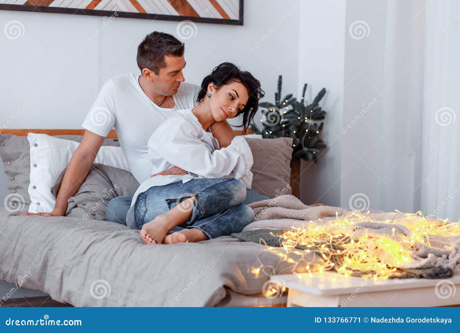 Attractive Cheerful Man And Woman On The Bed Hugging. Couple 