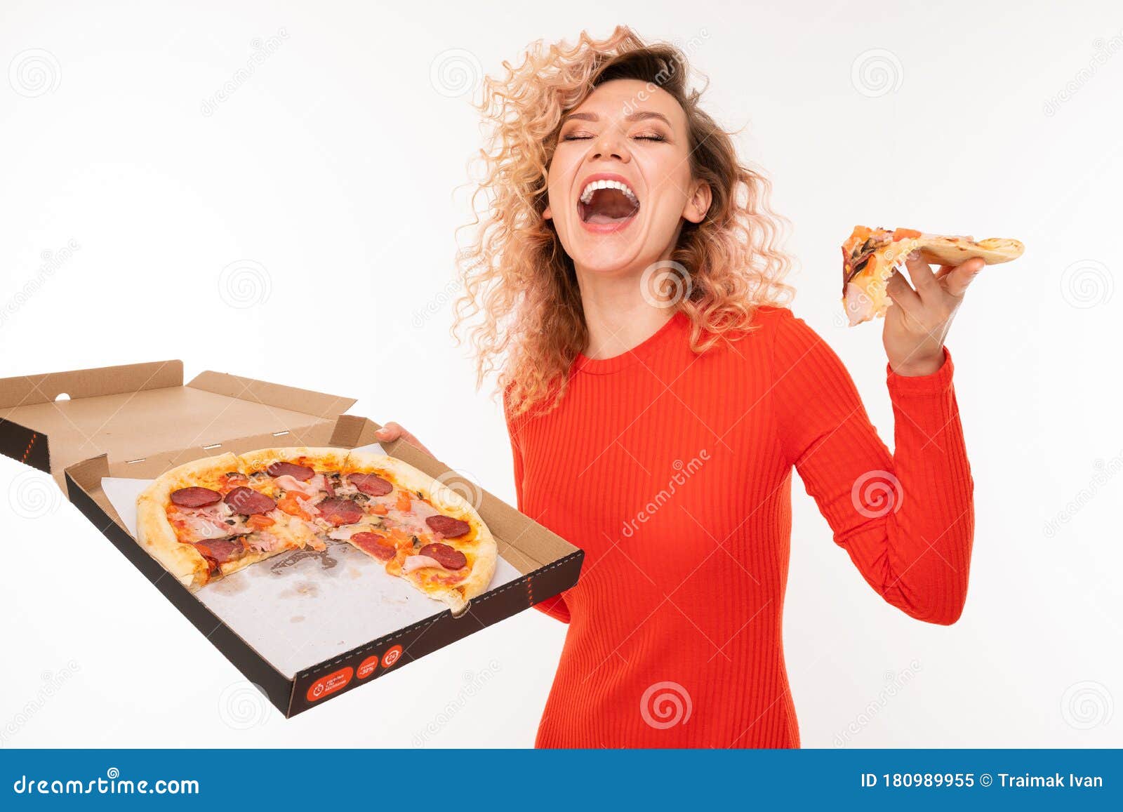 Attractive Curly Blond Girl Tries A Slice Of Pizza Holding A Box In Her 