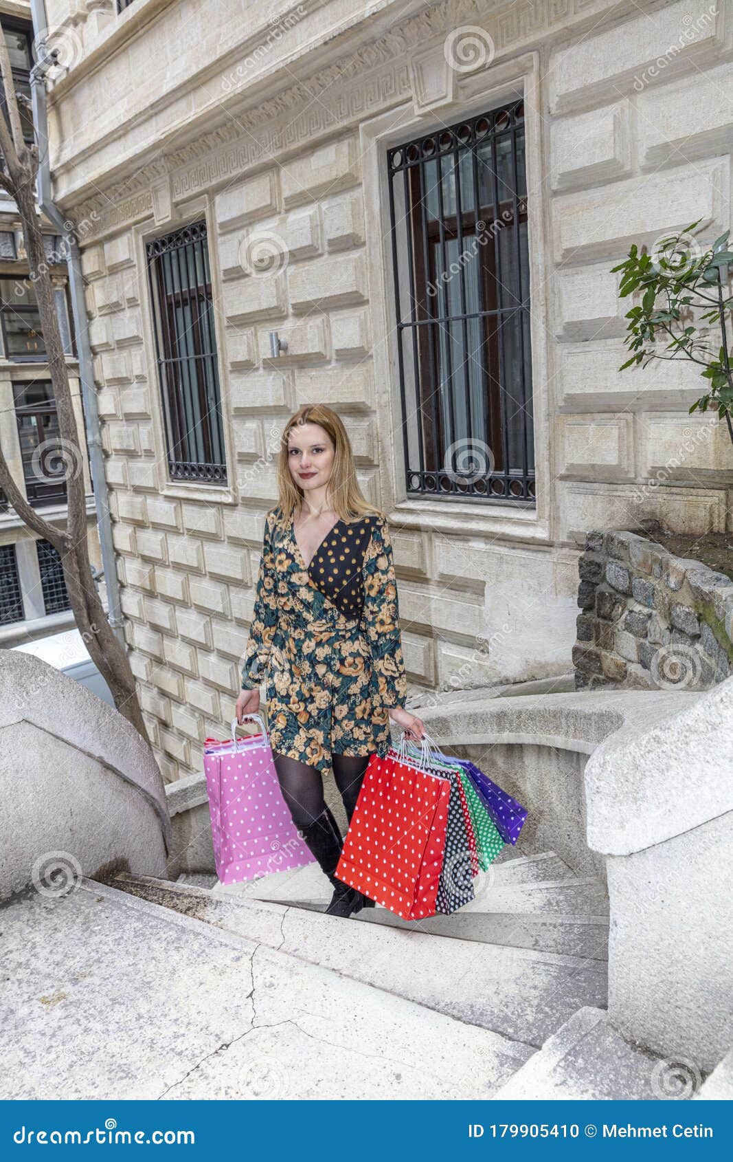 young woman holding colorful shopping bag with a happy smile. camondo stairs turkish: kamondo merdivenleri in galata district in