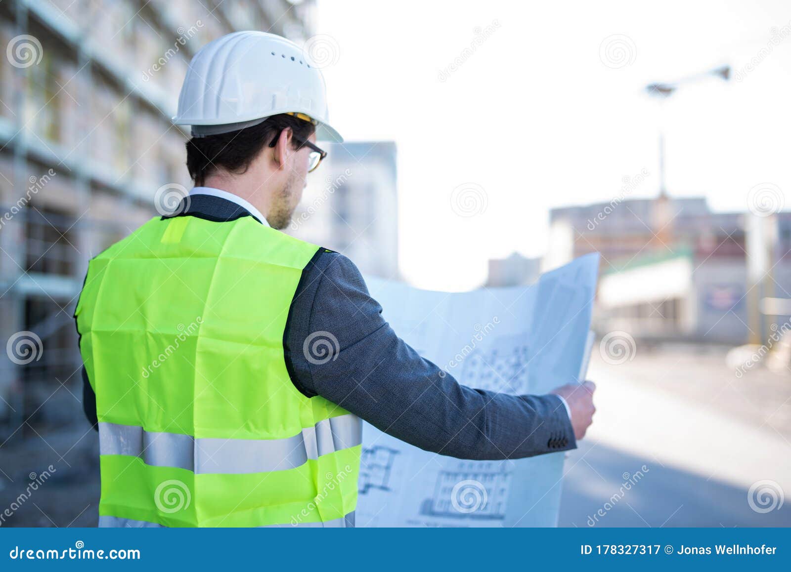 An Architect / Civil Engineer at Work on a Construction Site, Holding