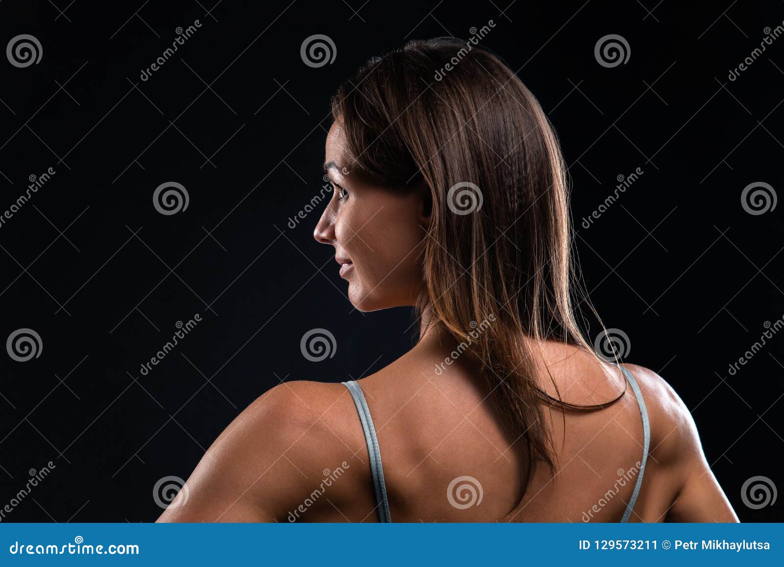 Attractive Fitness Woman Is Standing Back And Looking To The Side Stock