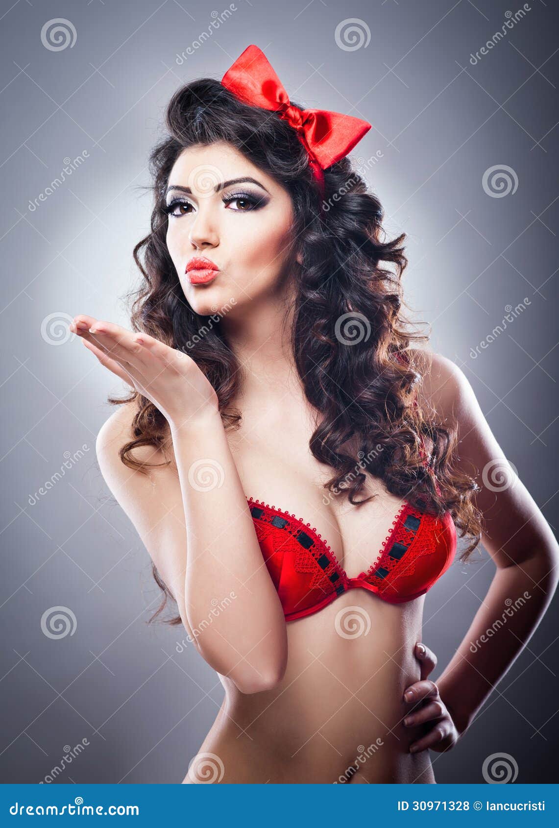 Attractive Girl with a Red Bow on Her Head and Red Bra Send a Kiss