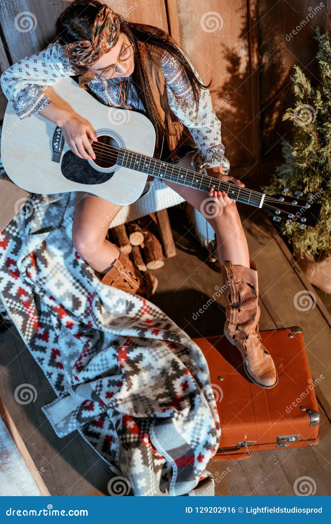 Attractive Hippie Girl In Headband And Glasses Playing Acoustic Guitar