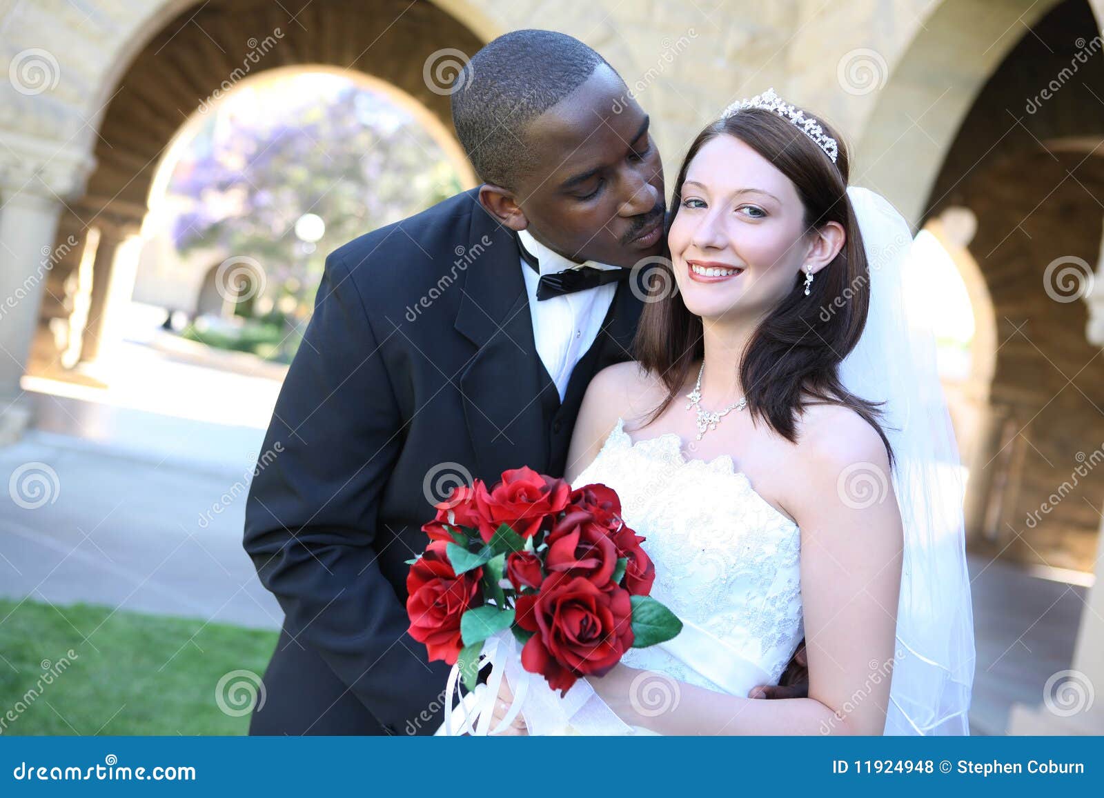 attractive interracial wedding couple kissing