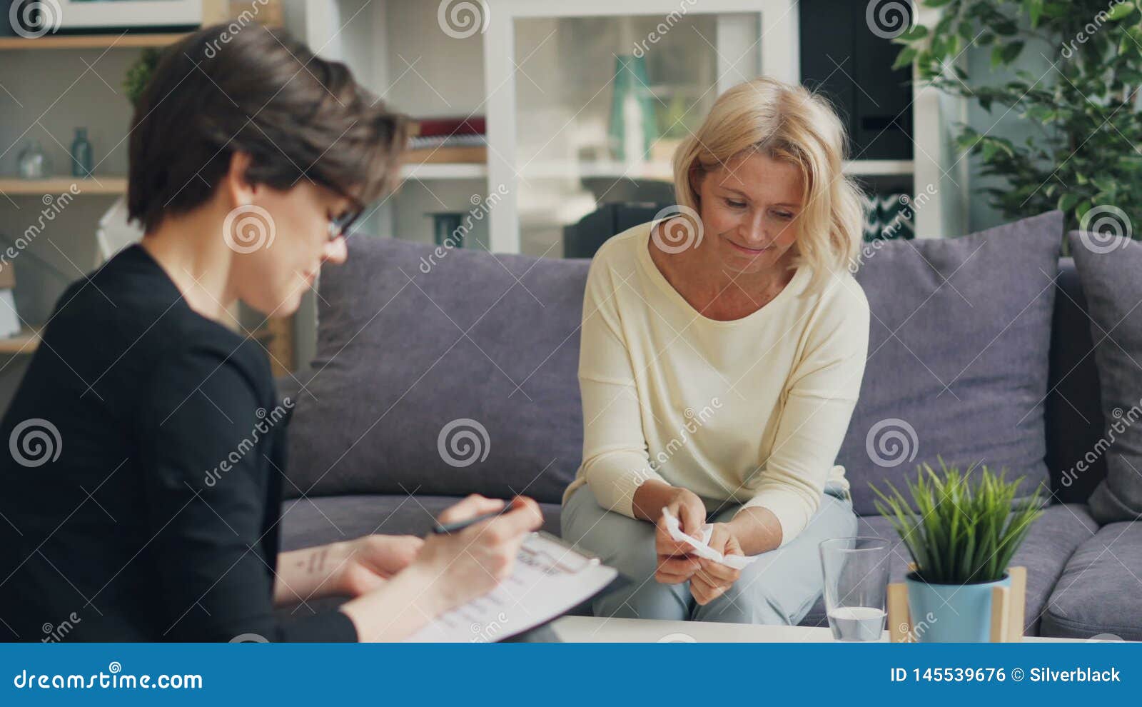 Mature Woman Talking To Female Psychologist Sitting On Couch In Modern Office Stock Footage