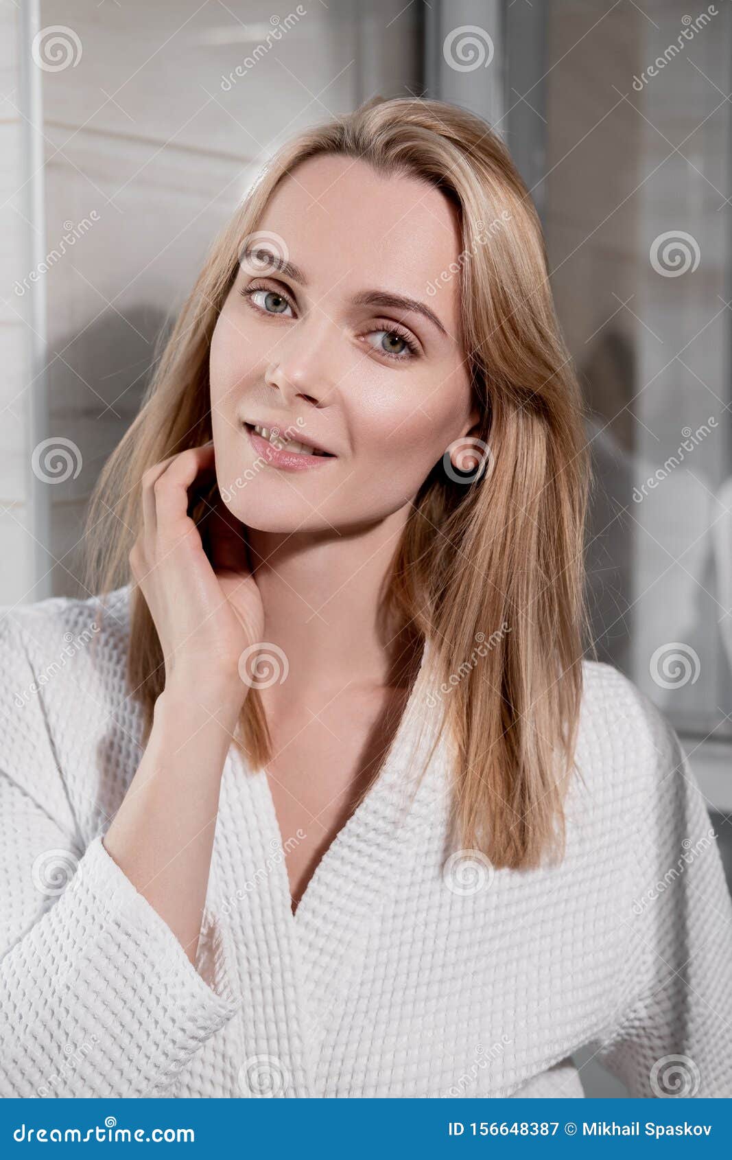 Attractive Middle Age Blond Woman In White Bathrobe In Bathroom He Enters The Glass Shower And