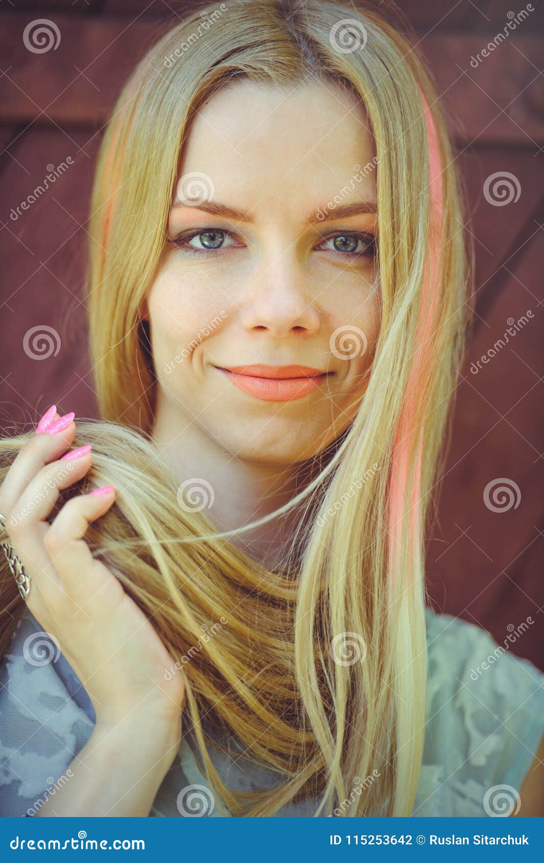 Attractive Modest Young Blond Woman Playing with Hair on Red Wooden ...