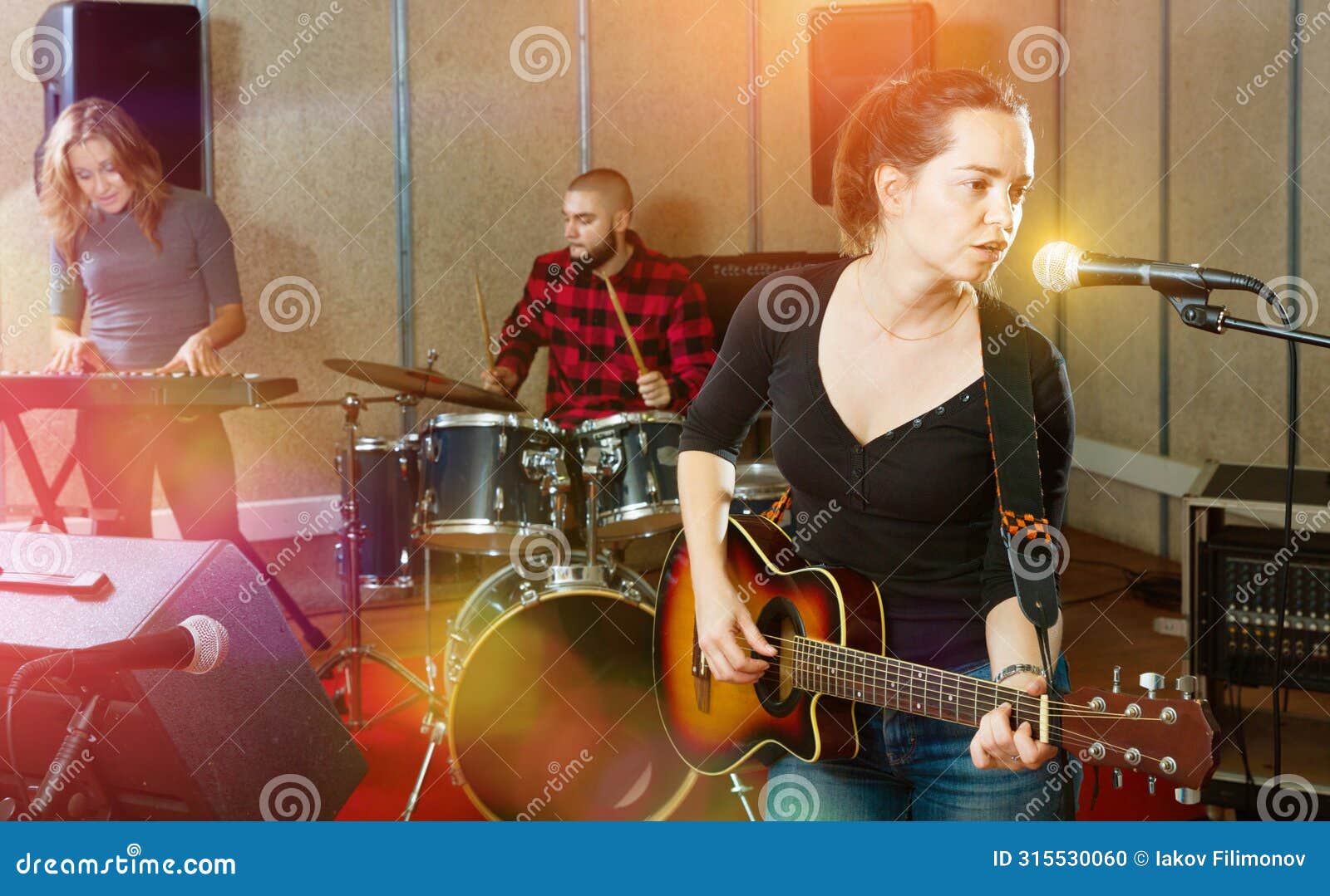 attractive female soloist playing guitar and singing with her mu
