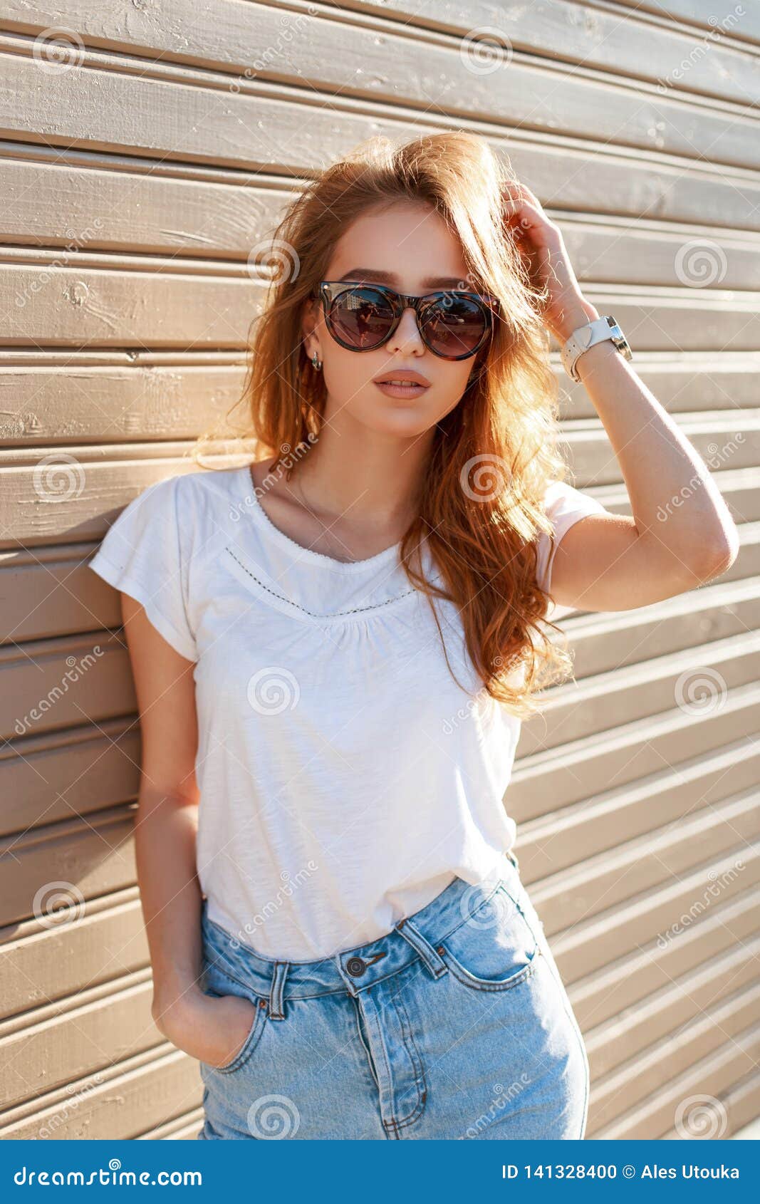 Attractive Pretty Young Hipster Woman with Stylish Hairstyle in Vintage  Sunglasses in Summer White T-shirt in Blue Stylish Jeans Stock Photo -  Image of model, cool: 141328400