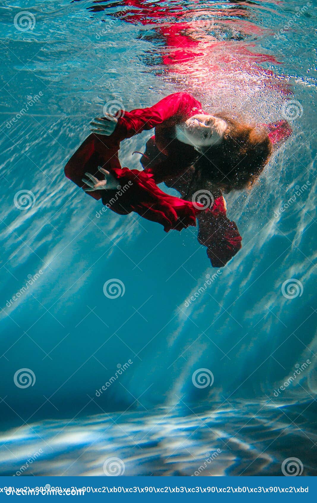 Attractive Red-haired Young Woman Swims Beautifully Underwater in a Red ...