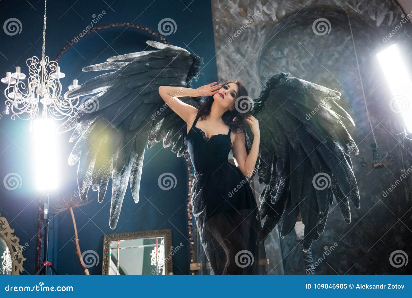 Sensual woman in black angel costume. Attractive sensual woman posing in black angel costume with big wings.