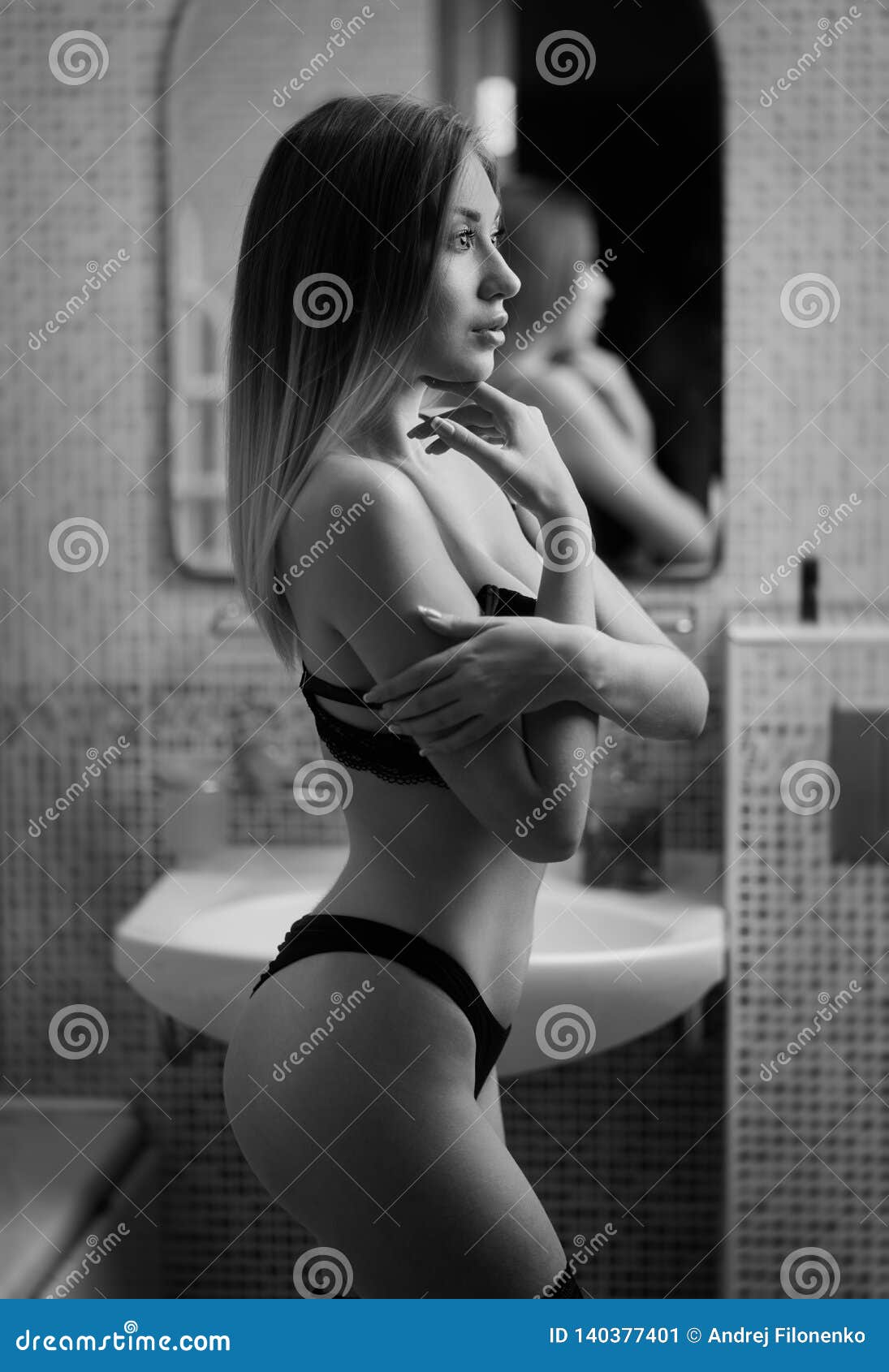 Beautiful Long-haired Slavic Girl in Lingerie Posing at the Open Door To the Bathroom with Her Arms Folded Elegantly Across Her Ch Stock Image pic