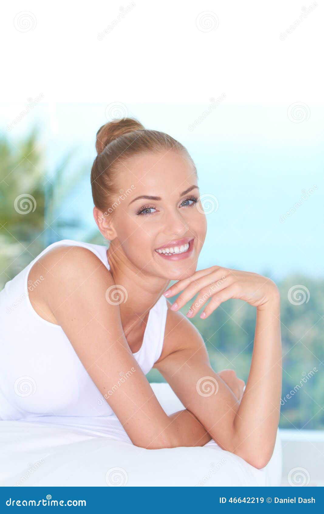 Attractive Smiling Woman Lying Prone On Bed Stock Image