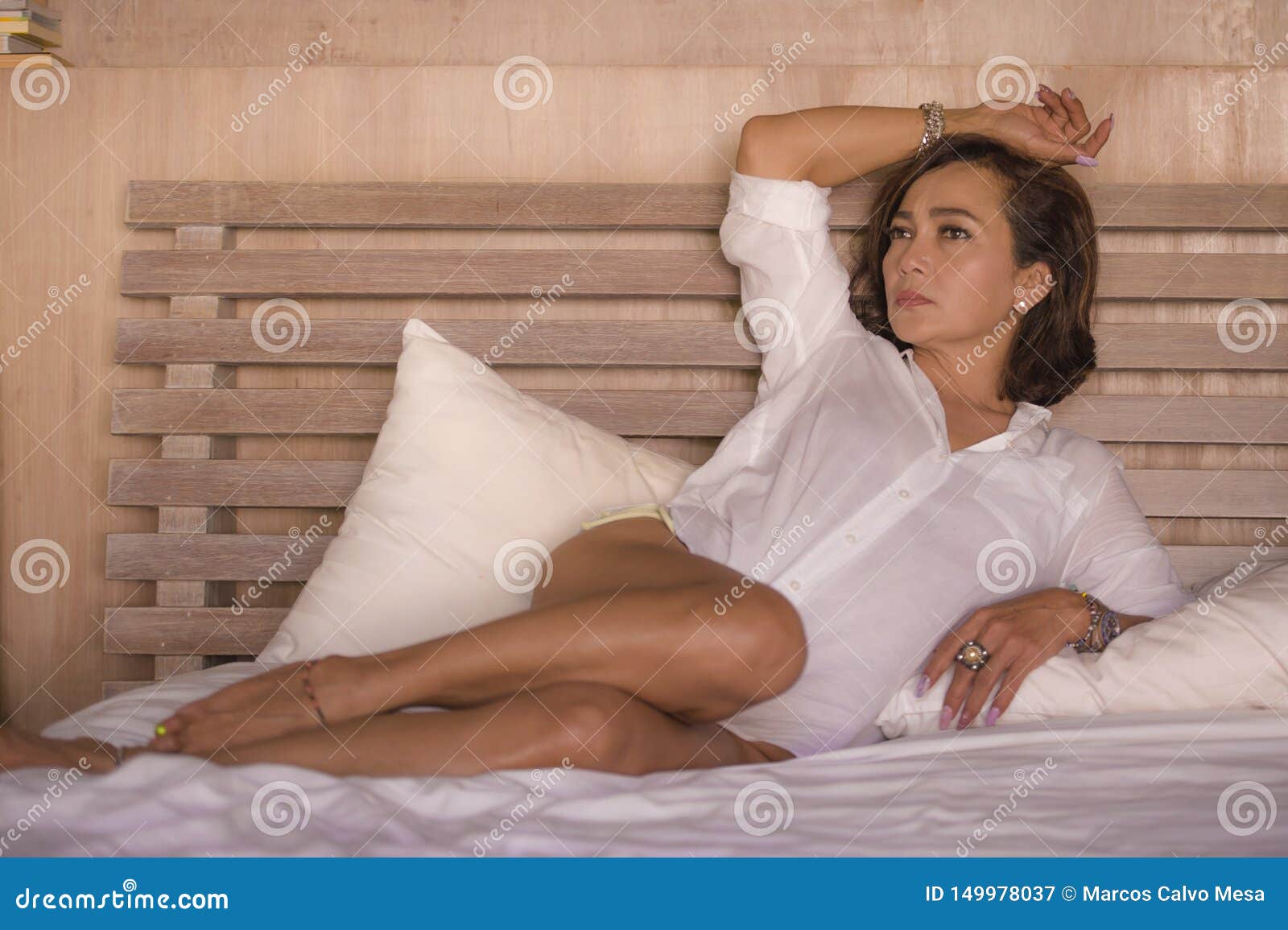 Attractive Successful and Mature Woman Aged 50s To 60s Relaxed and Confident at Home Bedroom Lying on Bed in the Morning Stock Image