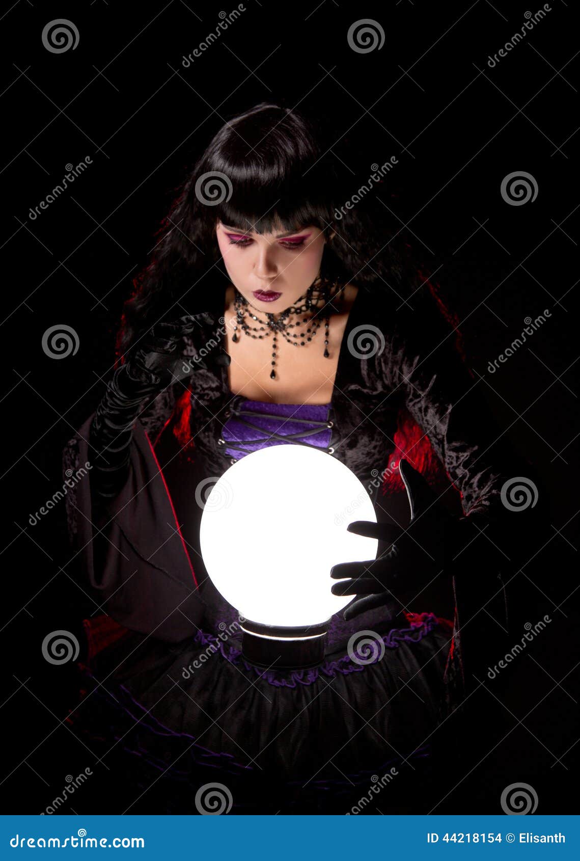 Attractive Witch or Fortune Teller Looking into a Crystal Ball Stock