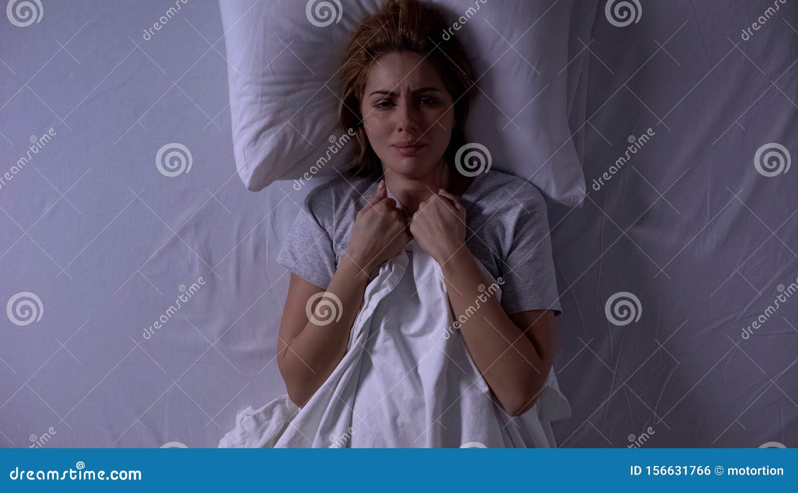 attractive woman crying lying in bed at night, female weakness and fragility