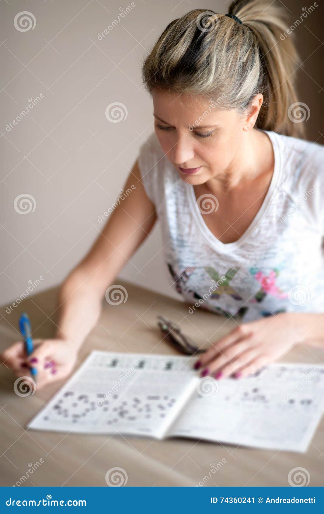 Attractive Woman Sitting Doing Crossword Puzzles Stock Image - Image of