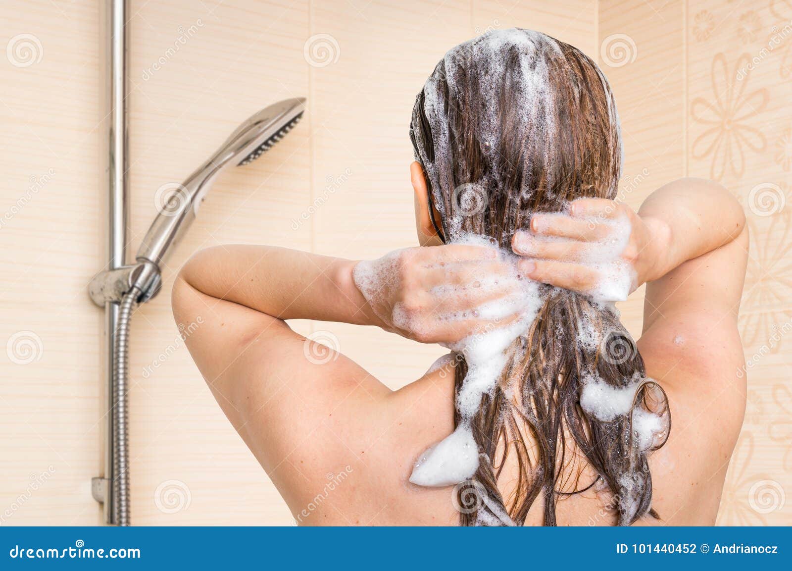 attractive woman washing her hair with shampoo in shower