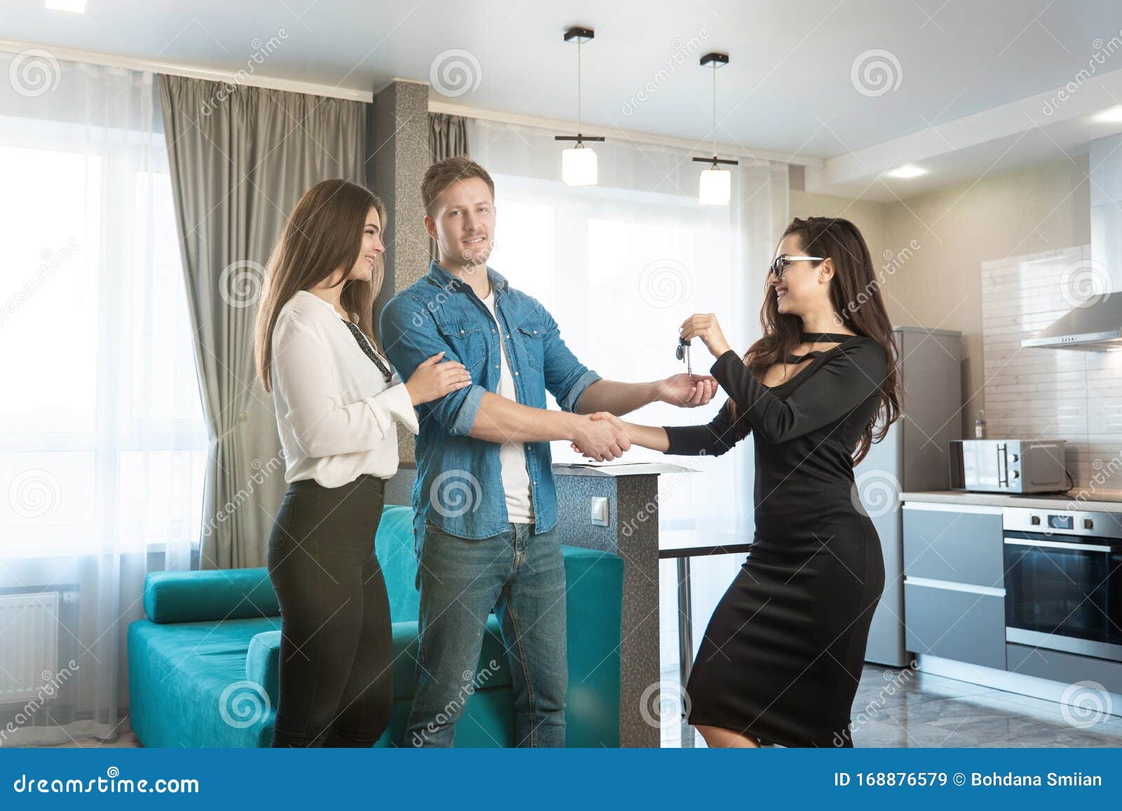 Attractive Woman Realtor Property Manager Giving Keys To Lovely Happy Clients Couple Husband And 