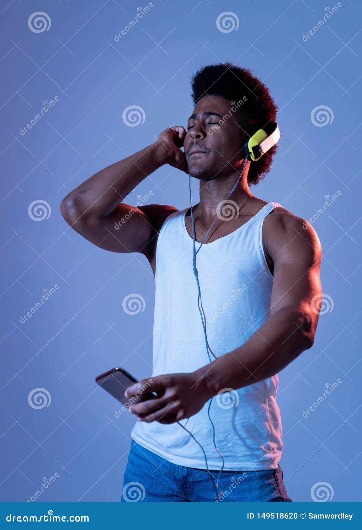 Attractive Young American Man with Headphones Listening To Music on Mobile in Disco Light Stock Photo - Image of dancing, american: 149518620
