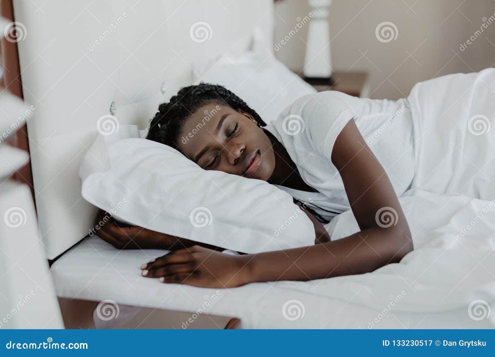 Attractive Young African American Woman Wakes Up In Her Bedroom At Home 