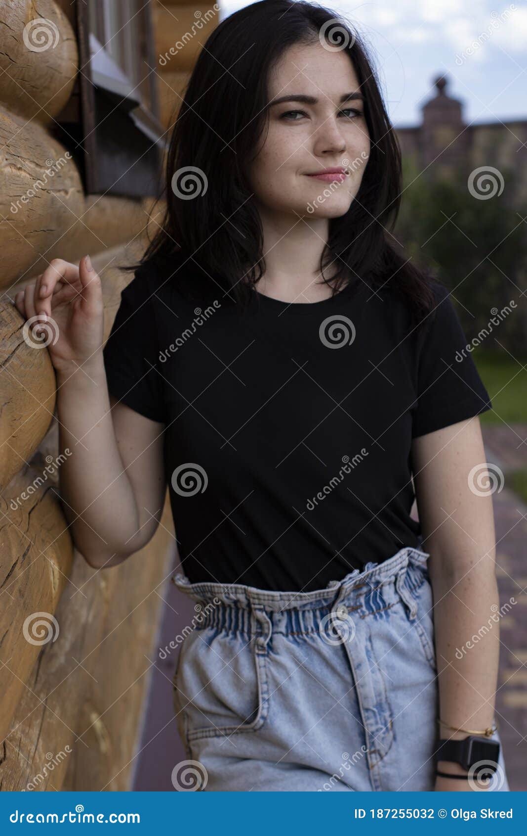 Attractive Young Brunette Woman in Black T-shirt and Denim Shorts Next ...