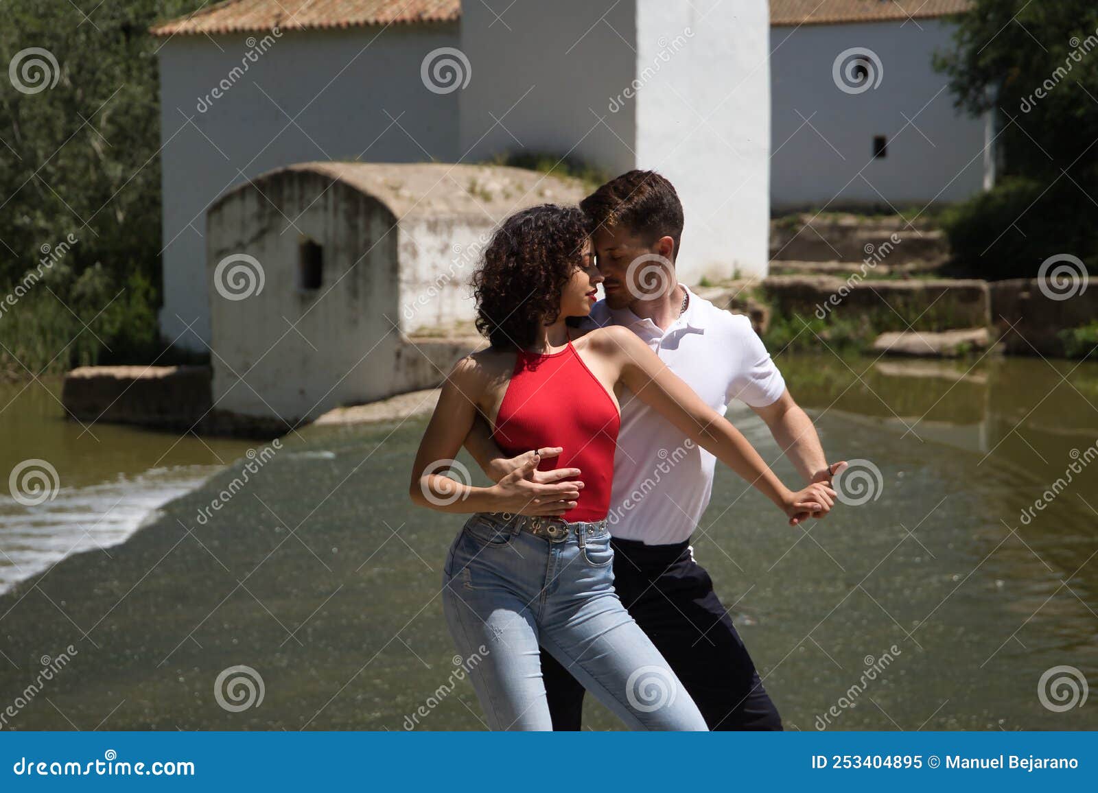 Attractive Young Couple Dancing Sensual Bachata On A Stone Floor In An Outdoor Park Next To A