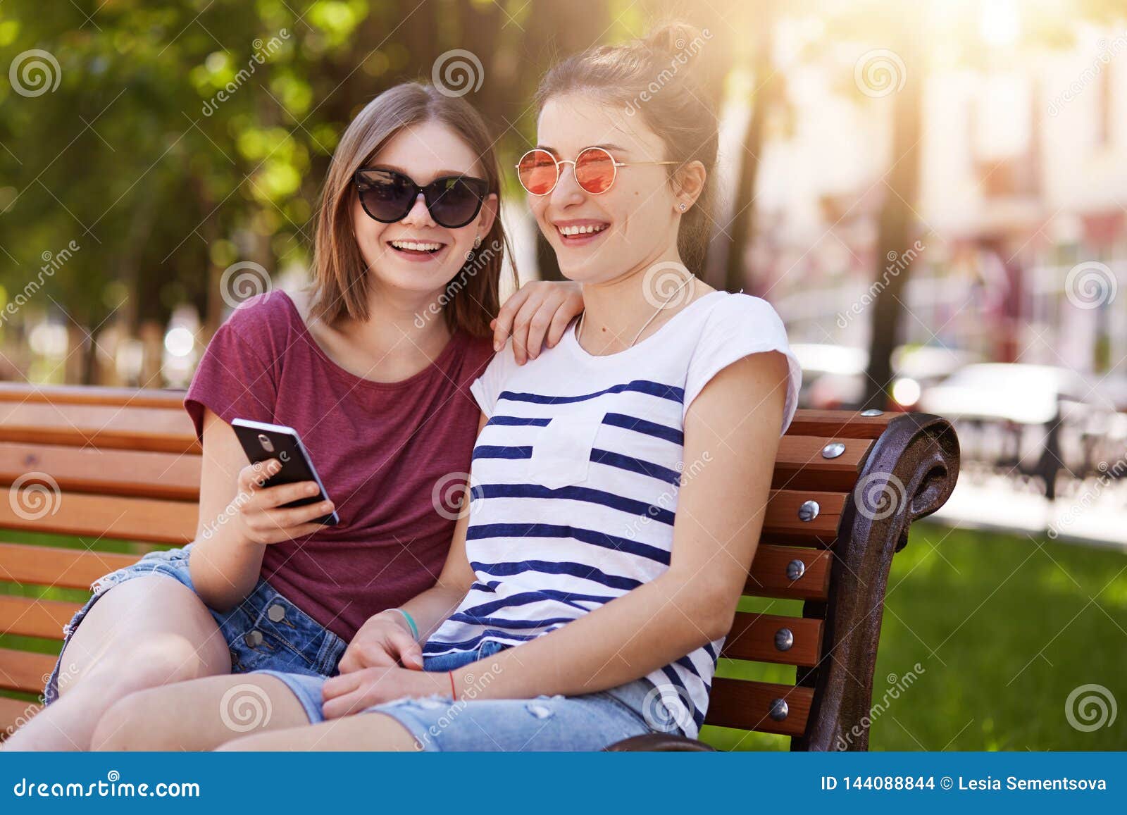 Attractive Young Friends Sit in the Park, Discuss Latest News in Their ...