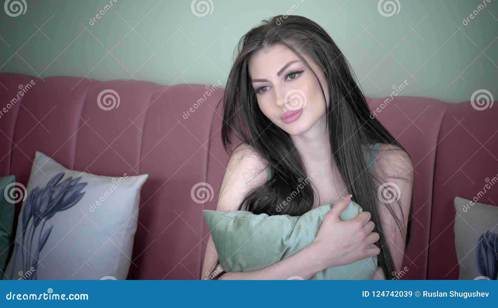 Attractive Young Girl With Long Dark Hair Playfully Looking At The Camera And Corrects Hairstyles