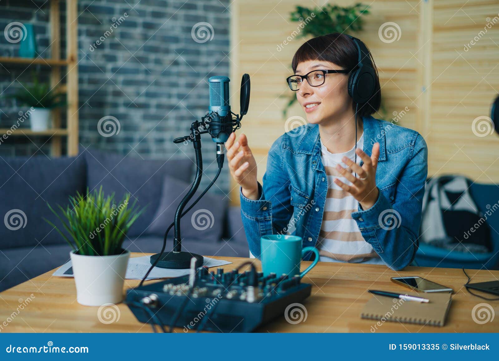 attractive young lady speaking in microphone gesturing in studio
