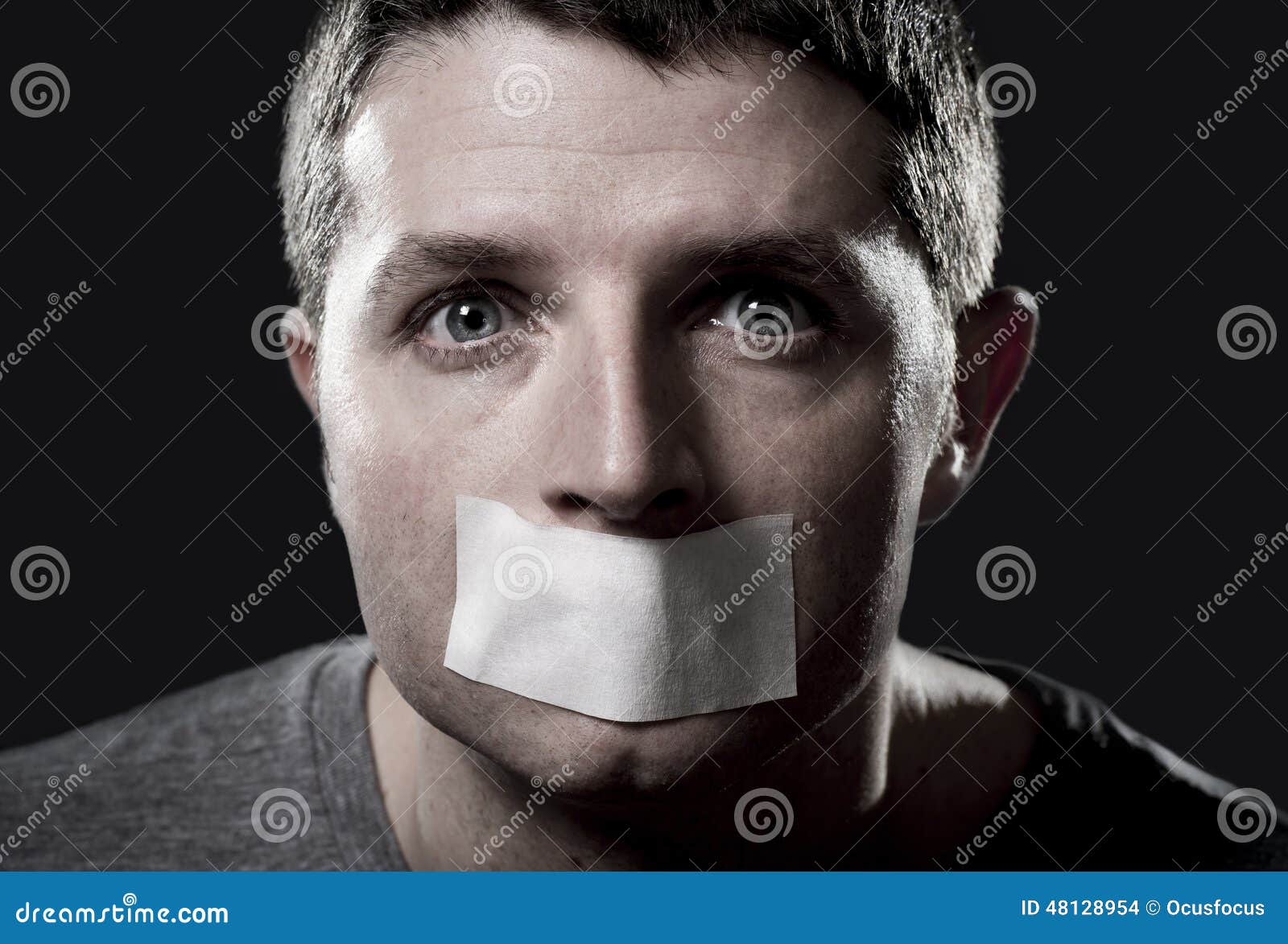 attractive young man with mouth sealed on duct tape to prevent him from speaking