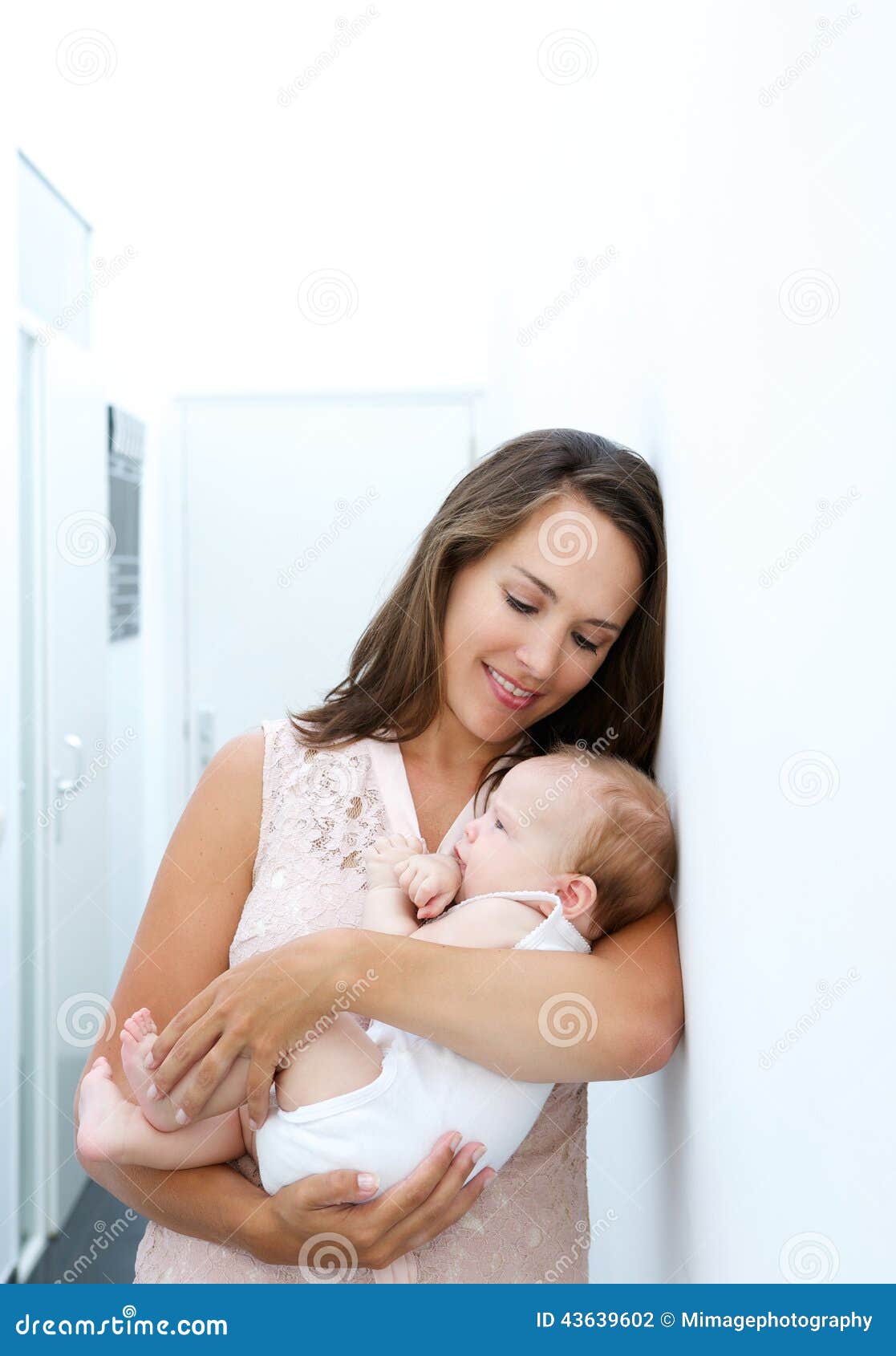 Portrait of an attractive young mother holding newborn baby at home