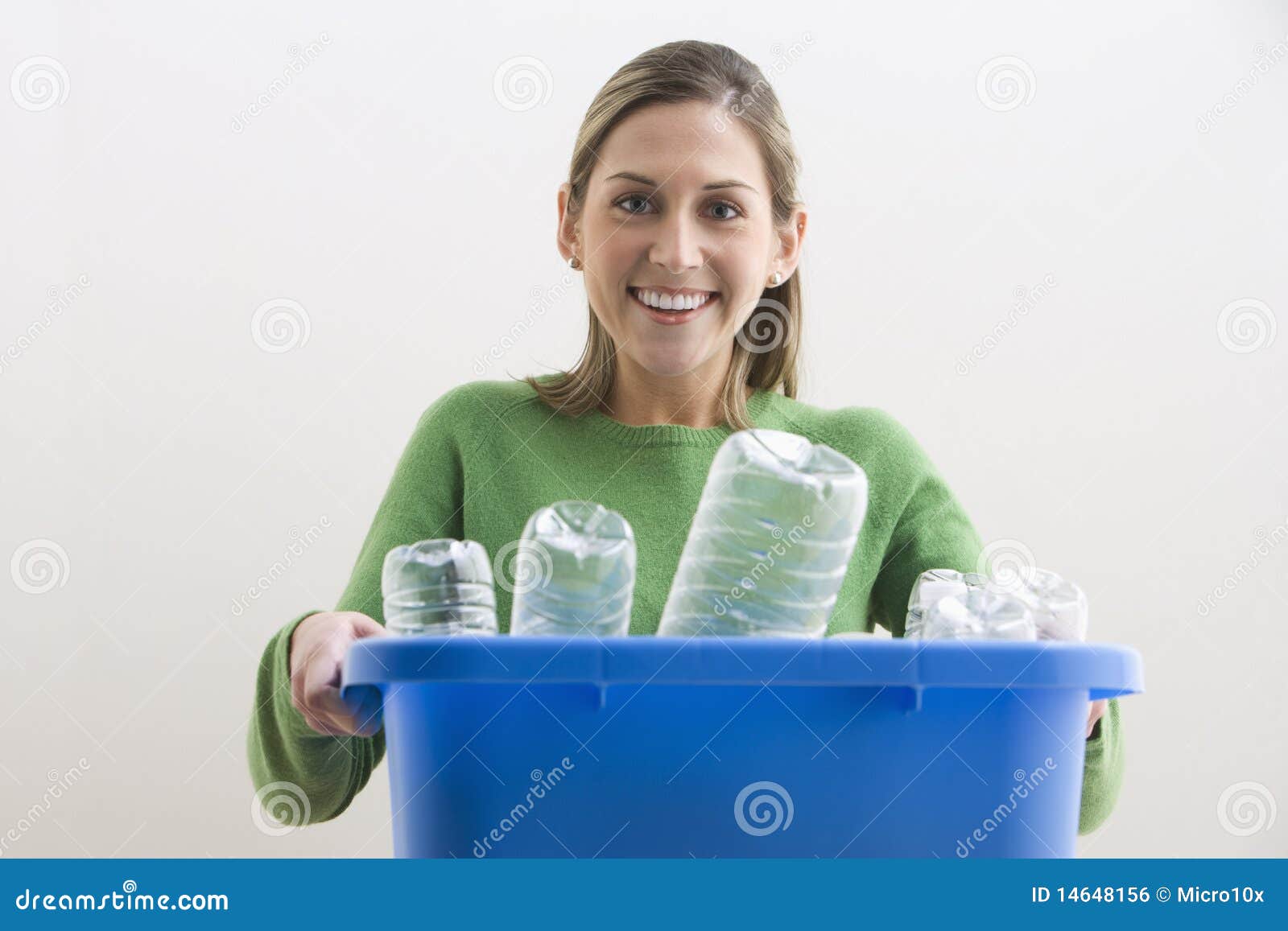 attractive young woman holding a blue recycle bin