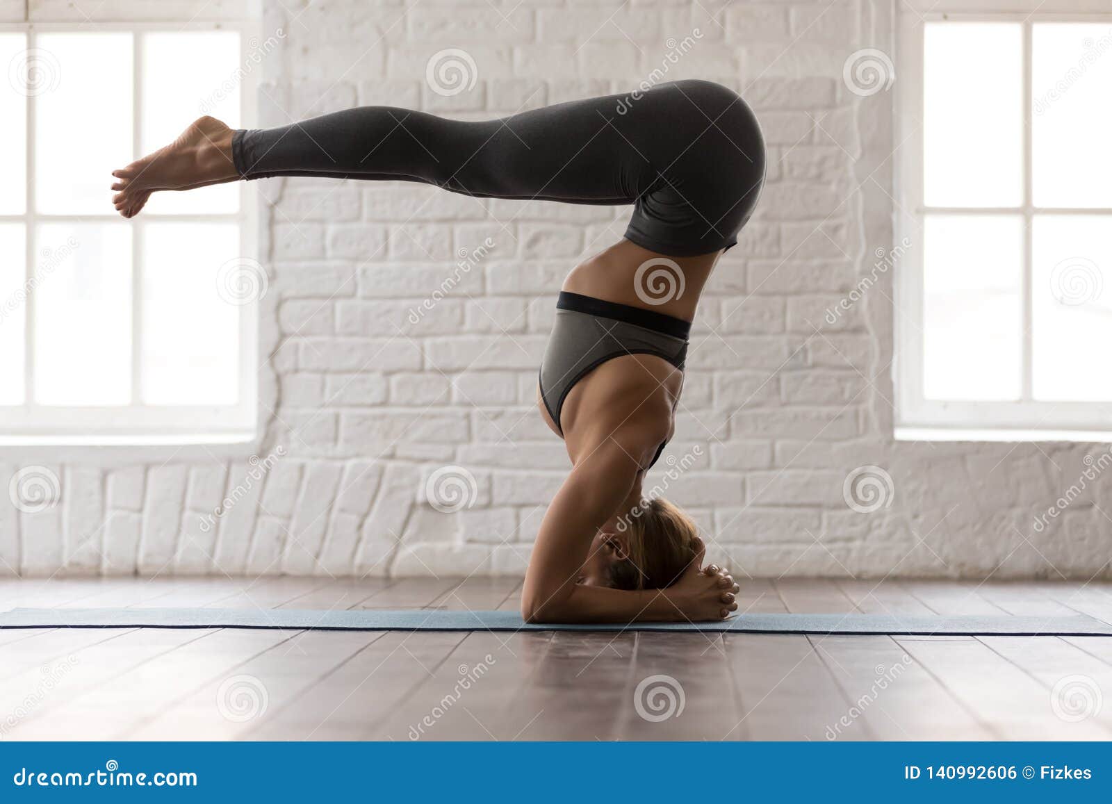 Attractive Woman Practicing Yoga, Standing in Headstand, Salamba ...