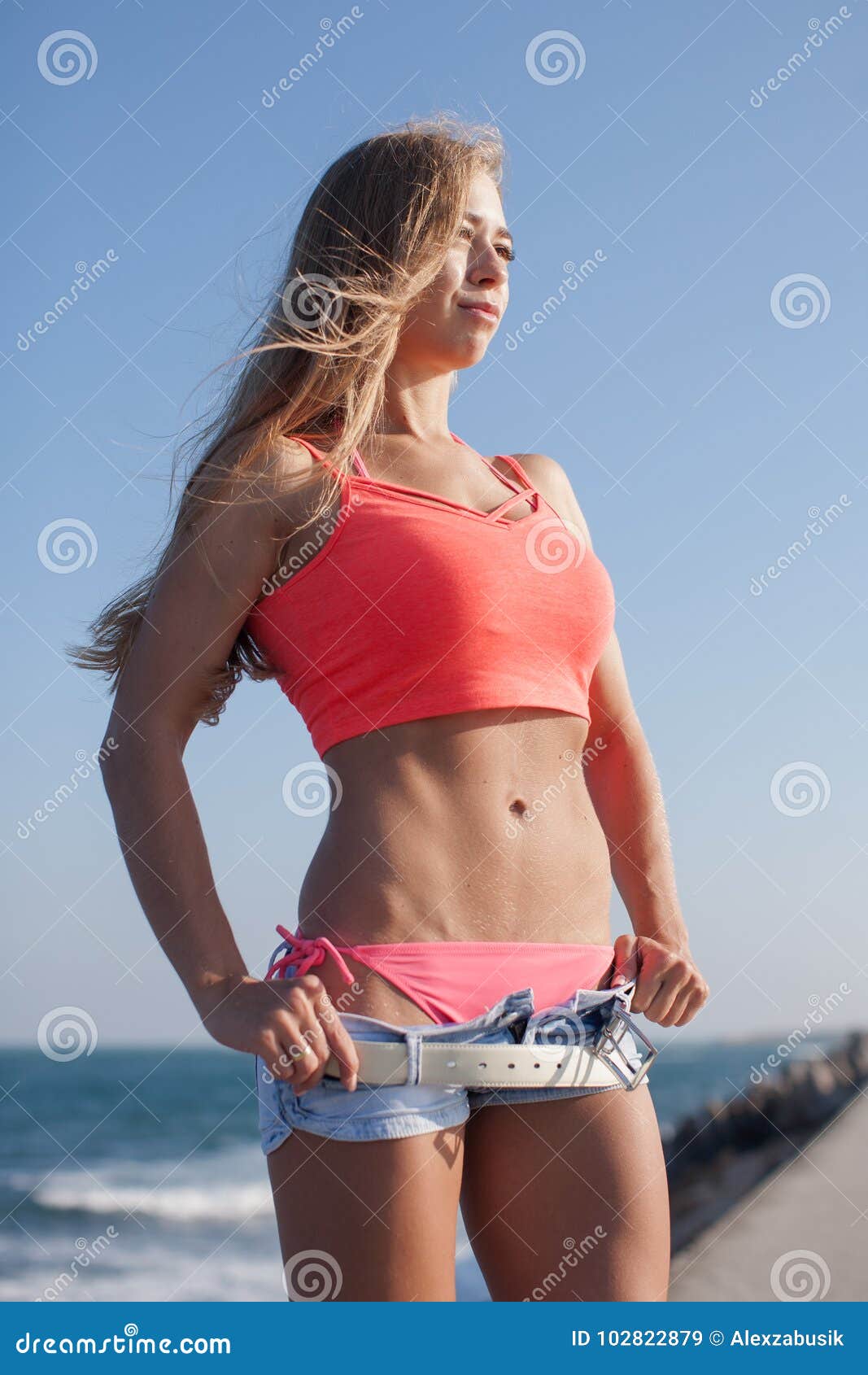 https://thumbs.dreamstime.com/z/attractive-young-woman-sagging-pants-hands-hips-athletic-blonde-standing-arms-akimbo-against-sea-102822879.jpg