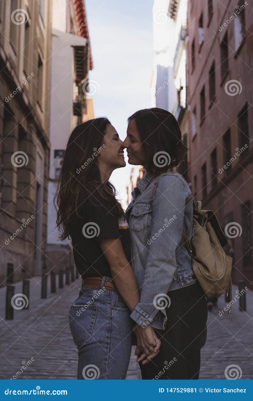 Attractive Young Women Lesbian Couple Kissing And Smiling In A Street Of Madrid Stock Image