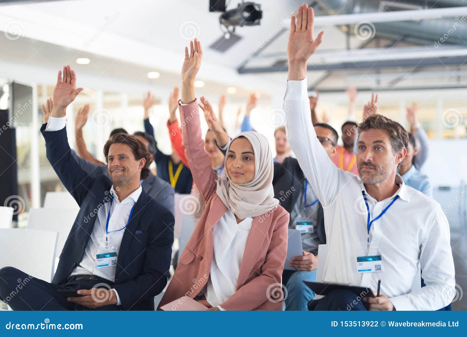 Audience Raising Their Hands in a Business Conference Stock Photo