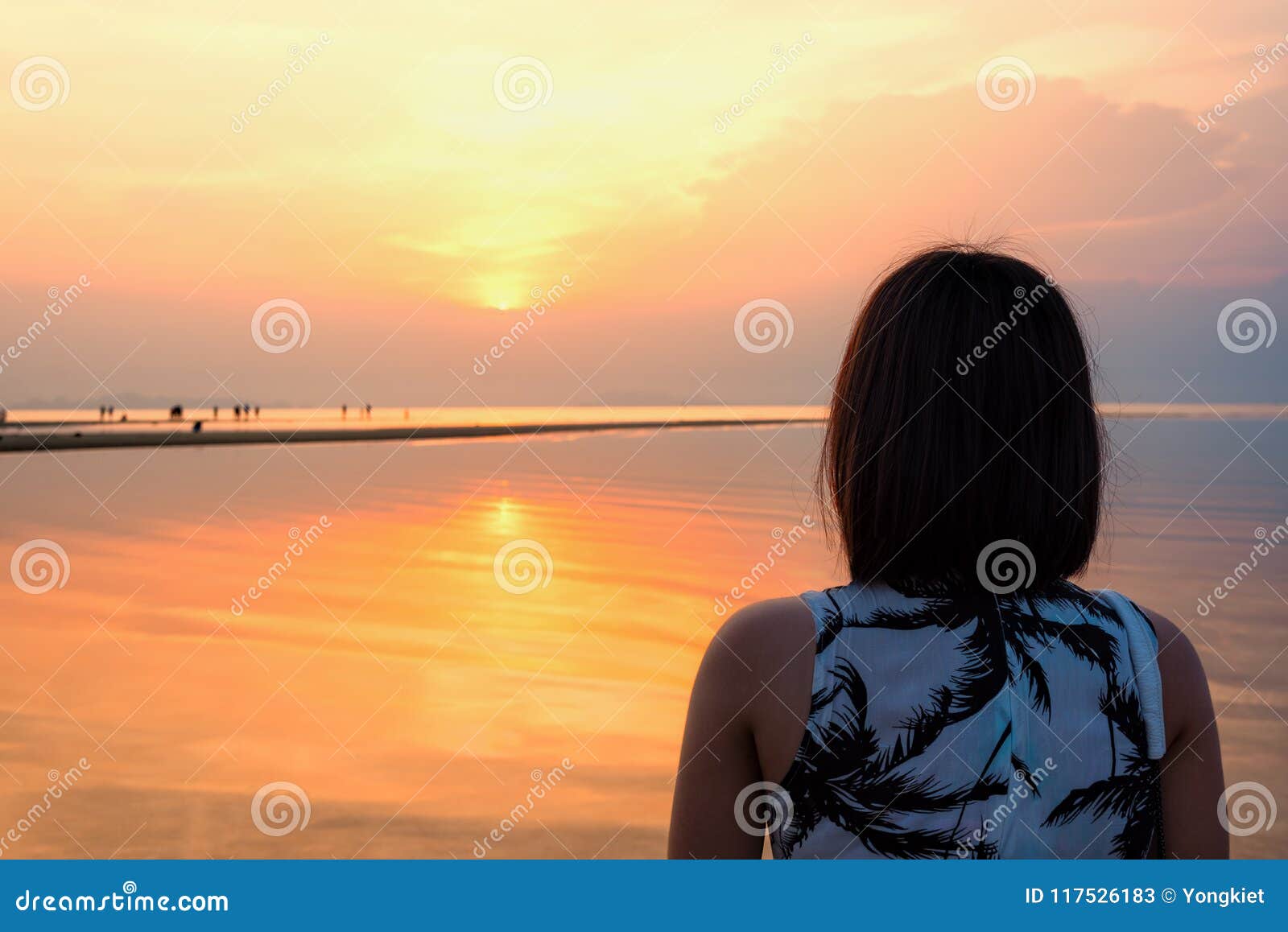 Aufpassender Sonnenuntergang der Frau am Strand. Junge Frau stehen, aufpassend die schöne Naturlandschaft, die vom Himmel und vom Meer während eines Sonnenuntergangs auf dem Strand am Nathon-Sonnenuntergang-Standpunkt in Insel Ko Samui, Surat Thani, Thailand bunt ist
