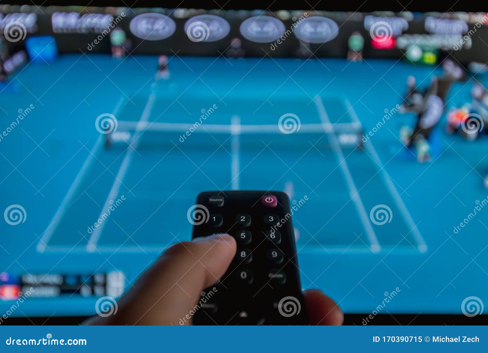 Aufpassendes Fernsehen Des Tennis Zu Hause Mit Fernbedienung in Der Hand Stockbild