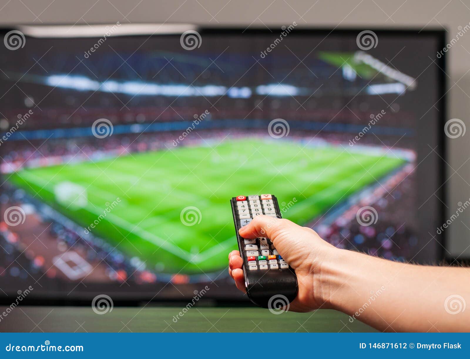 Aufpassendes Fu?ballspiel Des Mannes Im Fernsehen, Die Fernbedienung in Der Hand Stockfoto