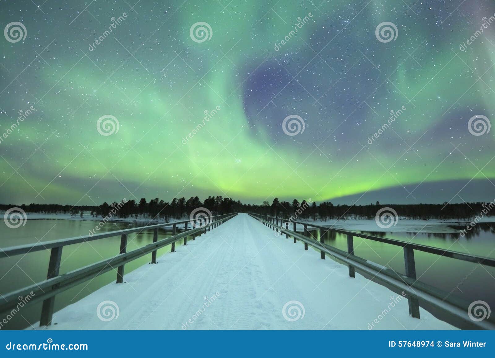 aurora borealis over a bridge in winter, finnish lapland