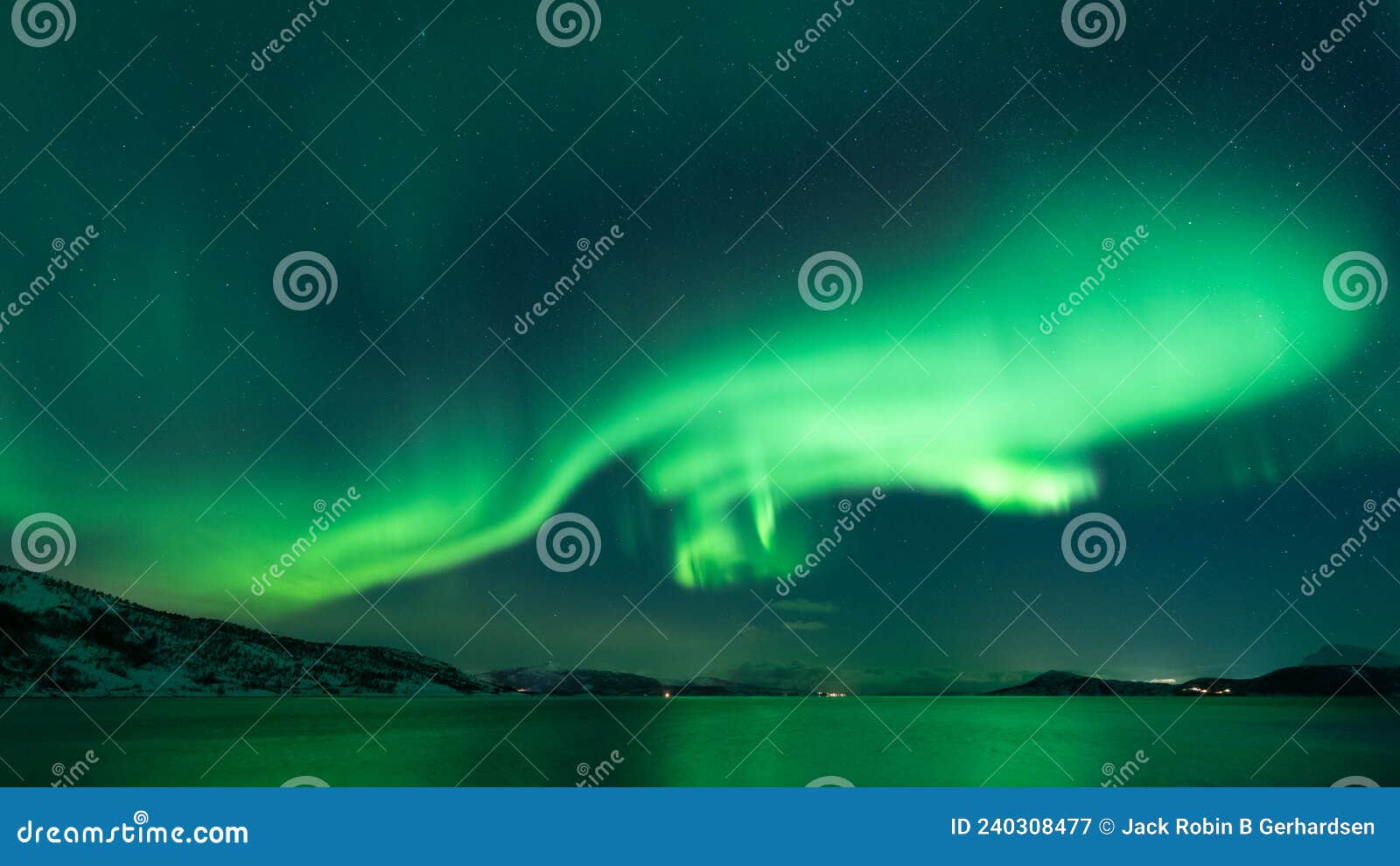 aurora whirling over the fjord reflecting in the sea