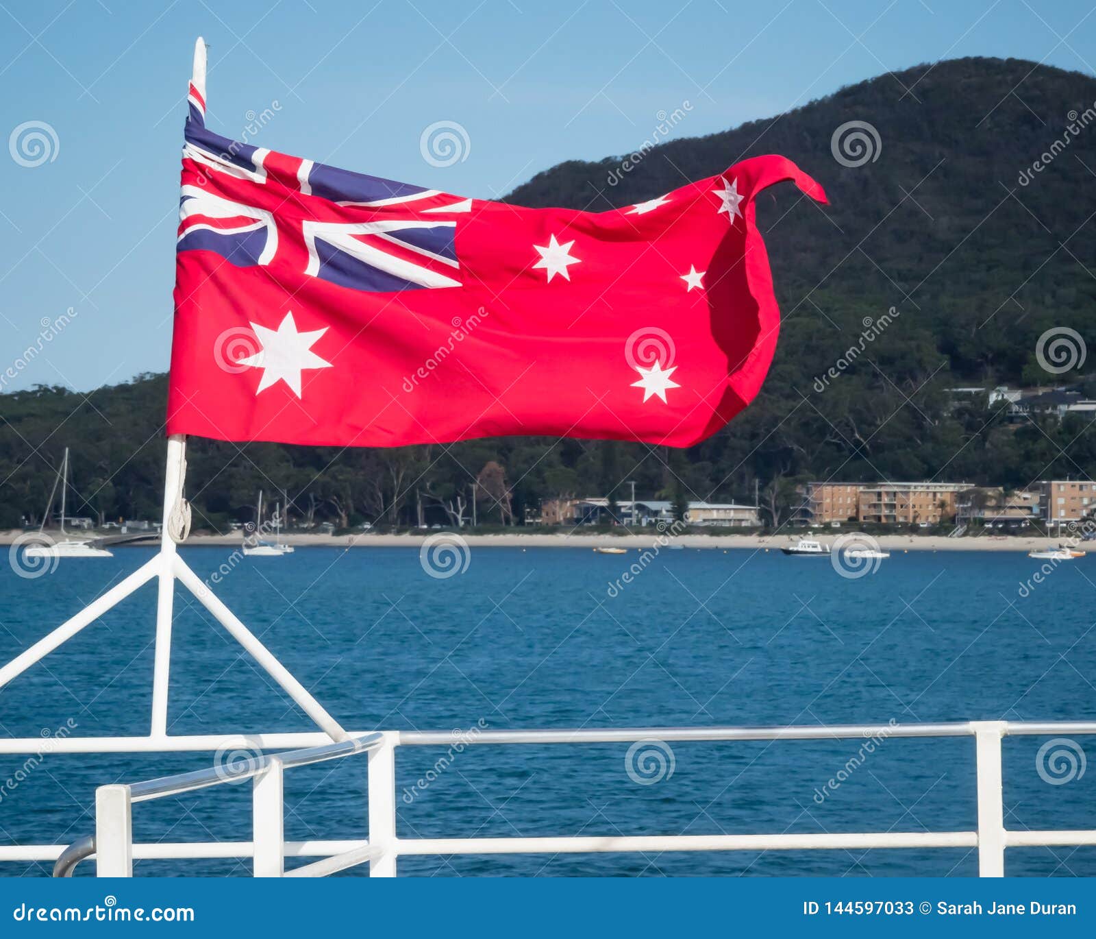 Australian Red Ensign Flag Flying from the Stern of Boat with a Natural Scene in Background Stock Image of stars, scene:
