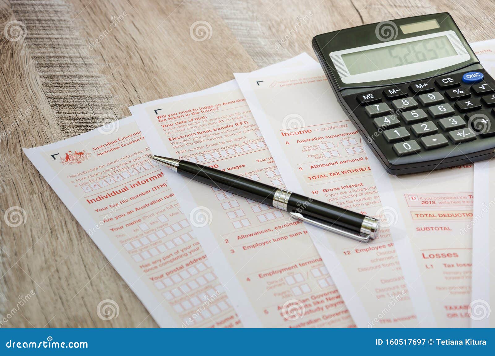 australian-tax-return-calculator-pen-on-a-wooden-table-close-up