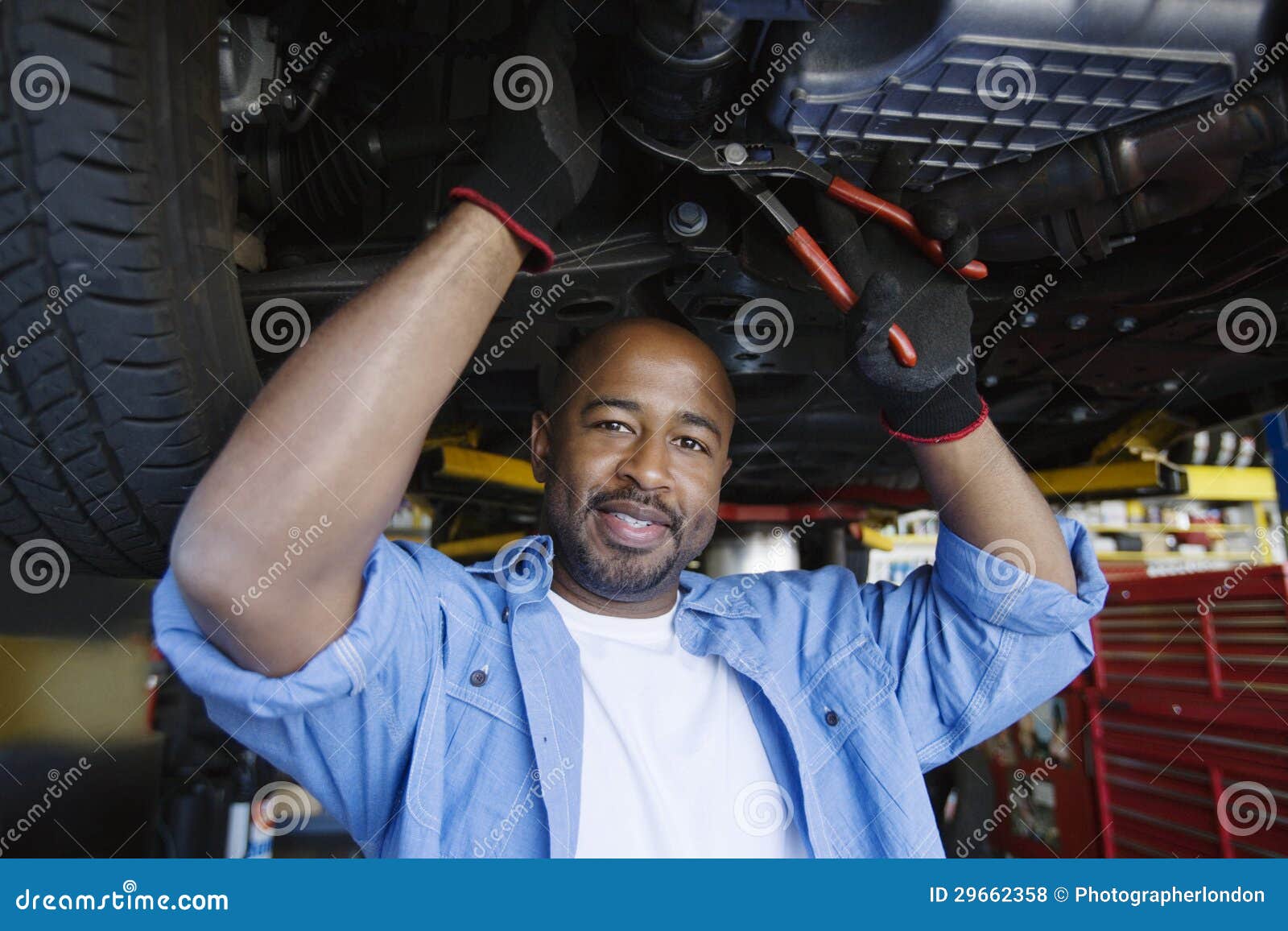 auto mechanic beneath a car