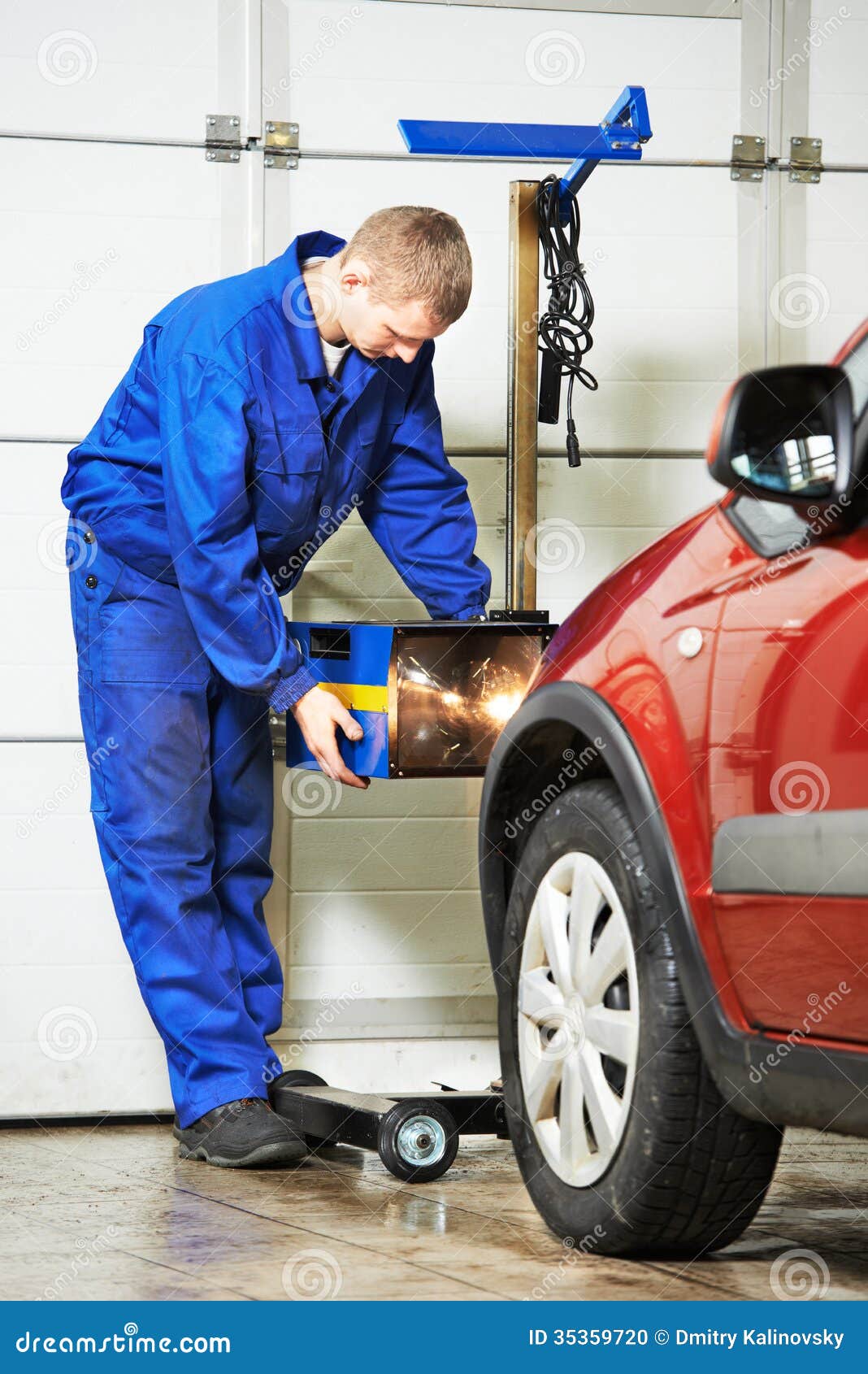 auto mechanic at car headlight checkup