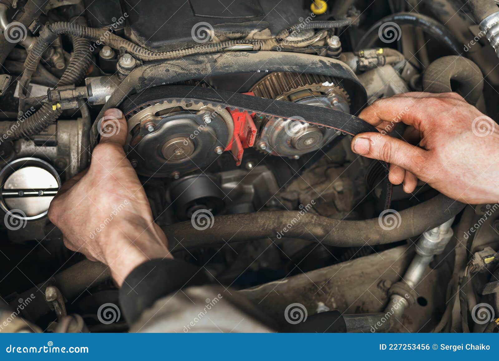 auto mechanic changes the timing belt in the car