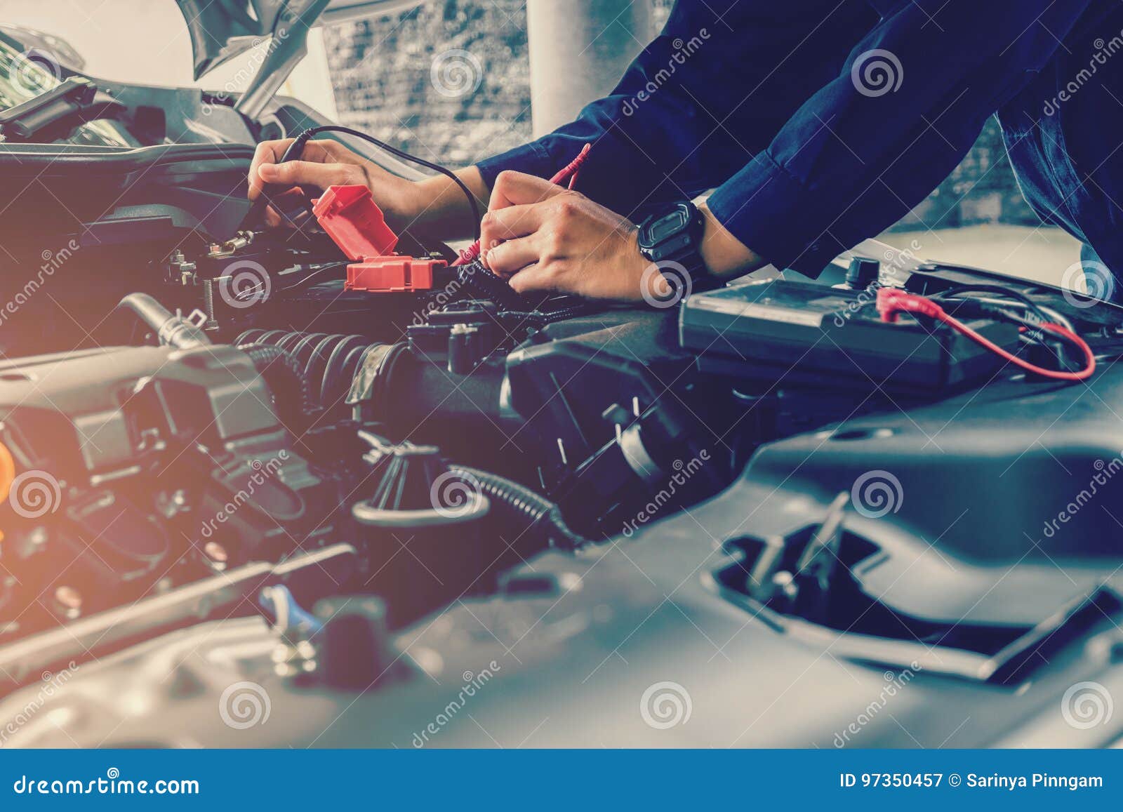 auto mechanic checking car battery voltage