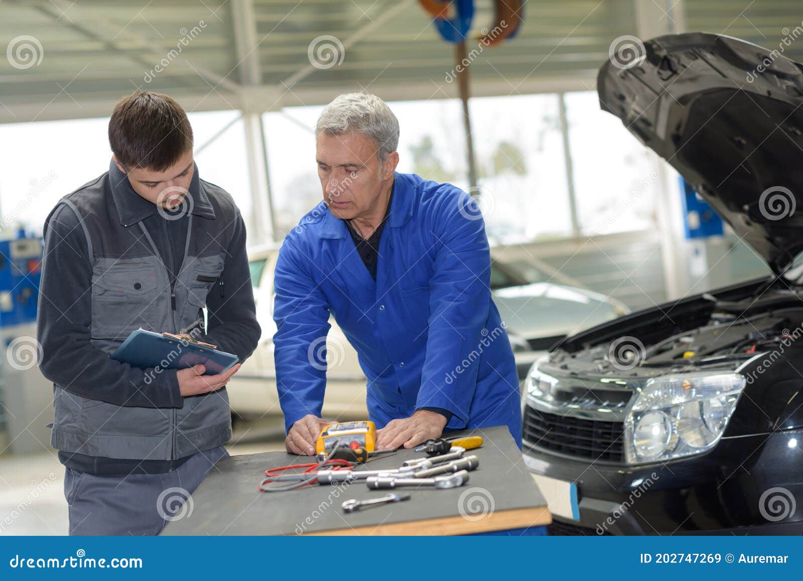 Auto Mechanic Teacher and Trainee Performing Tests at Mechanic School